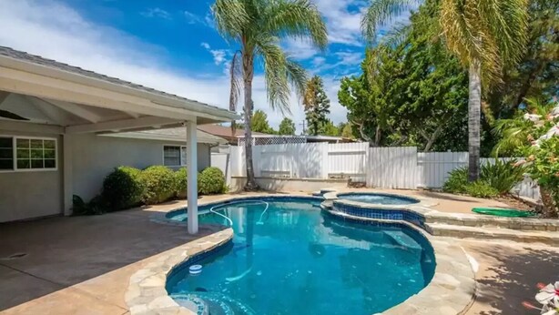 A backyard with a swimming pool, a covered patio, and a white fence. - Casa De for 8people/3BD 3BA, 10people/3BD 4BA,+12people/4BD 4BA (Thousand Oaks)