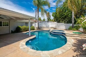 A backyard with a swimming pool, a covered patio, and a white fence. - Casa De for 8people/3BD 3BA, 10people/3BD 4BA,+12people/4BD 4BA (Thousand Oaks)