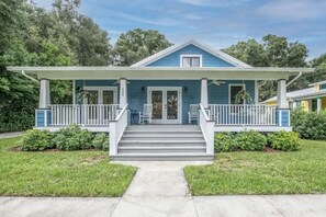 A two-story house with a front porch, a covered entryway, and a front yard.