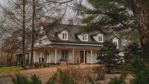 Una casa a due piani con tetto a punta, un portico e un camino.