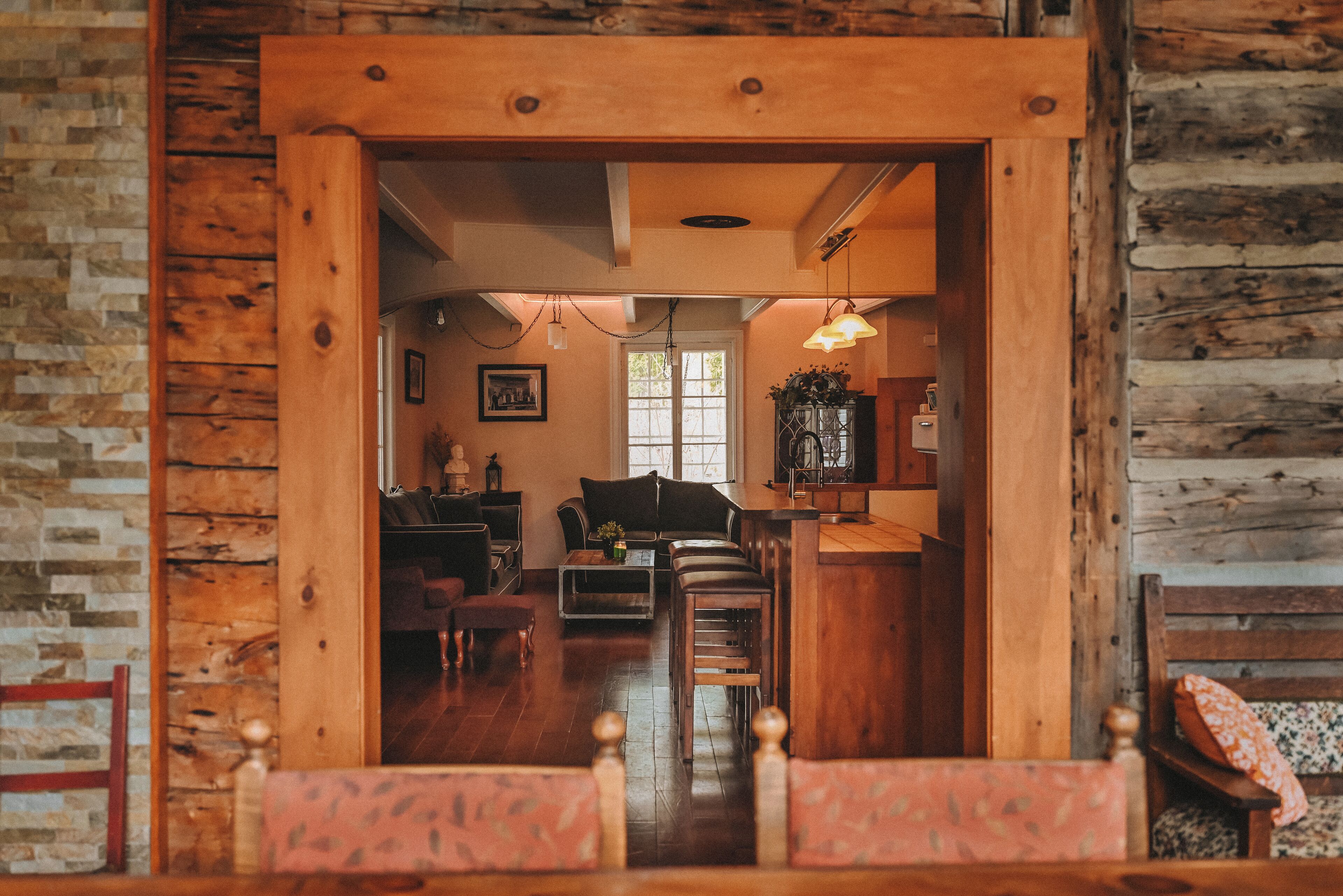 A rustic wooden interior with a dining area, a kitchen, and a living space.