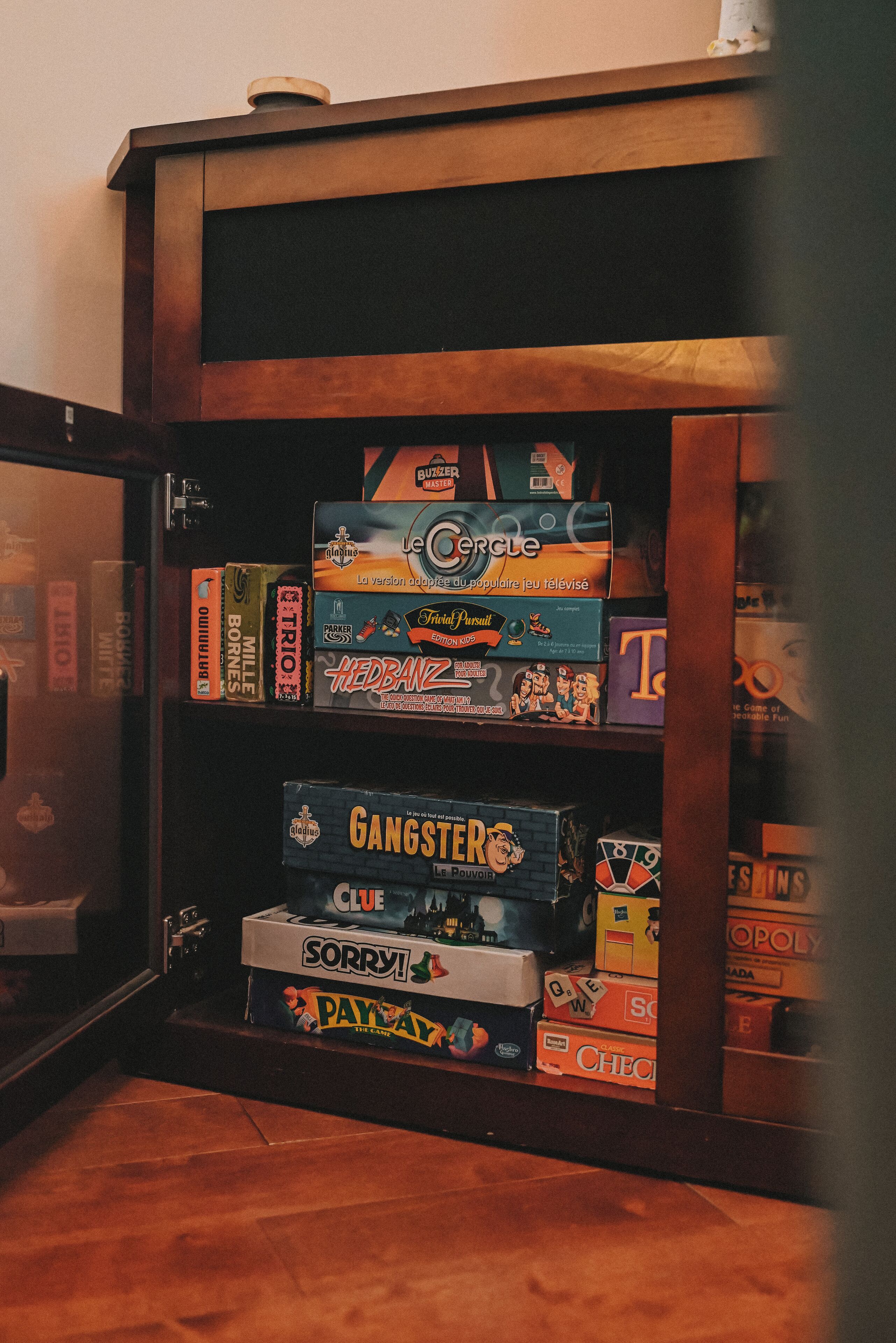 A wooden cabinet with various board games.