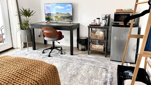 Een moderne kantoorruimte met een bureau, stoel, computer en koffiezetapparaat.