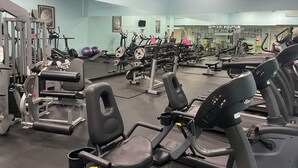 A gym with various exercise equipment, including treadmills and weight machines. - Beachfront Condo on Mustang Padre Island (Corpus Christi)
