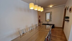 Ein moderner Konferenzraum mit einem langen Tisch, Stühlen und einer Deckenleuchte.