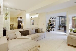 Una sala de estar moderna con un sofá, una mesa de centro y una estantería.