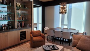 Una sala moderna con barra, una mesa de comedor y un sofá.