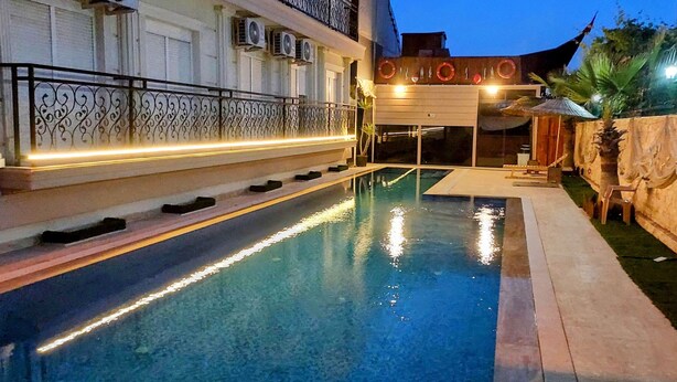 Una piscina amb una barana decorativa i un petit espai per seure.