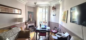 Une pièce avec une cheminée, une table à manger avec des chaises, un canapé et un téléviseur.