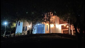 A building with a blue door and illuminated windows at night. - Amazing & Eco-friendly Beach house (Palomino)