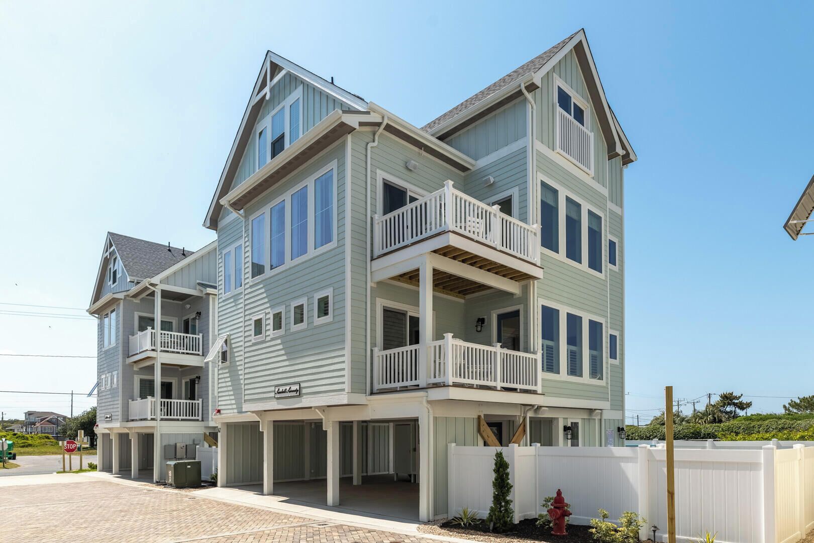 A multi-story building with a balcony on the second floor and a covered porch area.