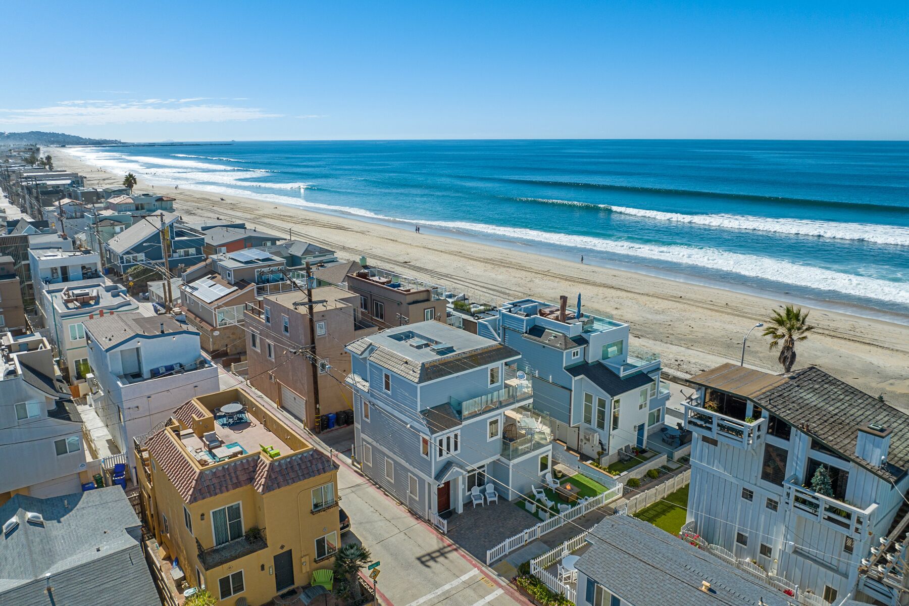 A coastal residential area with houses directly adjacent to a beach.