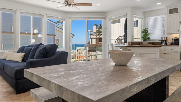 A modern kitchen with a large island, white cabinetry, and a view of the ocean. - The Mission Beach VIP- Luxury Home, 3 Private Decks, 30 steps to the Beach!  (San Diego)