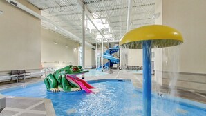 Un parco acquatico al chiuso con un'ampia scivolata, un'attrazione a tema rana e una zona piscine.