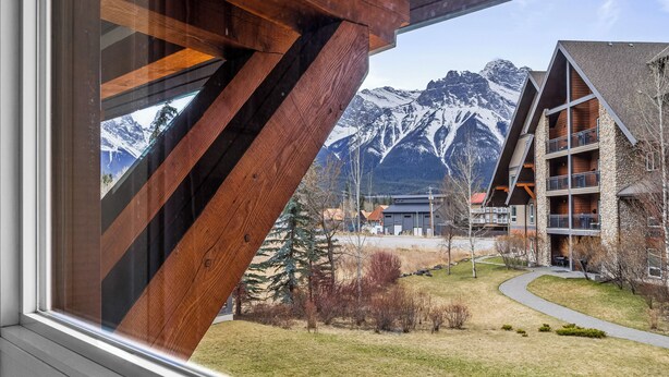 Un edificio moderno con facciata in legno e vista sulle montagne innevate.