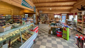 A cozy, wooden interior with a checkered floor, glass display cases, and various items on shelves and tables. - 2 bedroom awesome home in Grue Finnskog (Grue Finnskog)