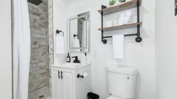 Bañera con ducha, cabezal de ducha tipo lluvia, secador de pelo, toallas