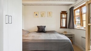 A bedroom with a bed, a nightstand, a window with curtains, and wall art. - Lovely home in Rudkøbing with WiFi (Rudkøbing)