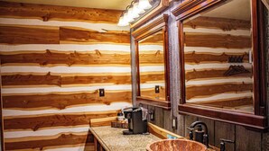 A rustic cabin-style bathroom with wooden walls, a wooden sink, and a coffee bar. - Farm House Room #10 S (Satin)