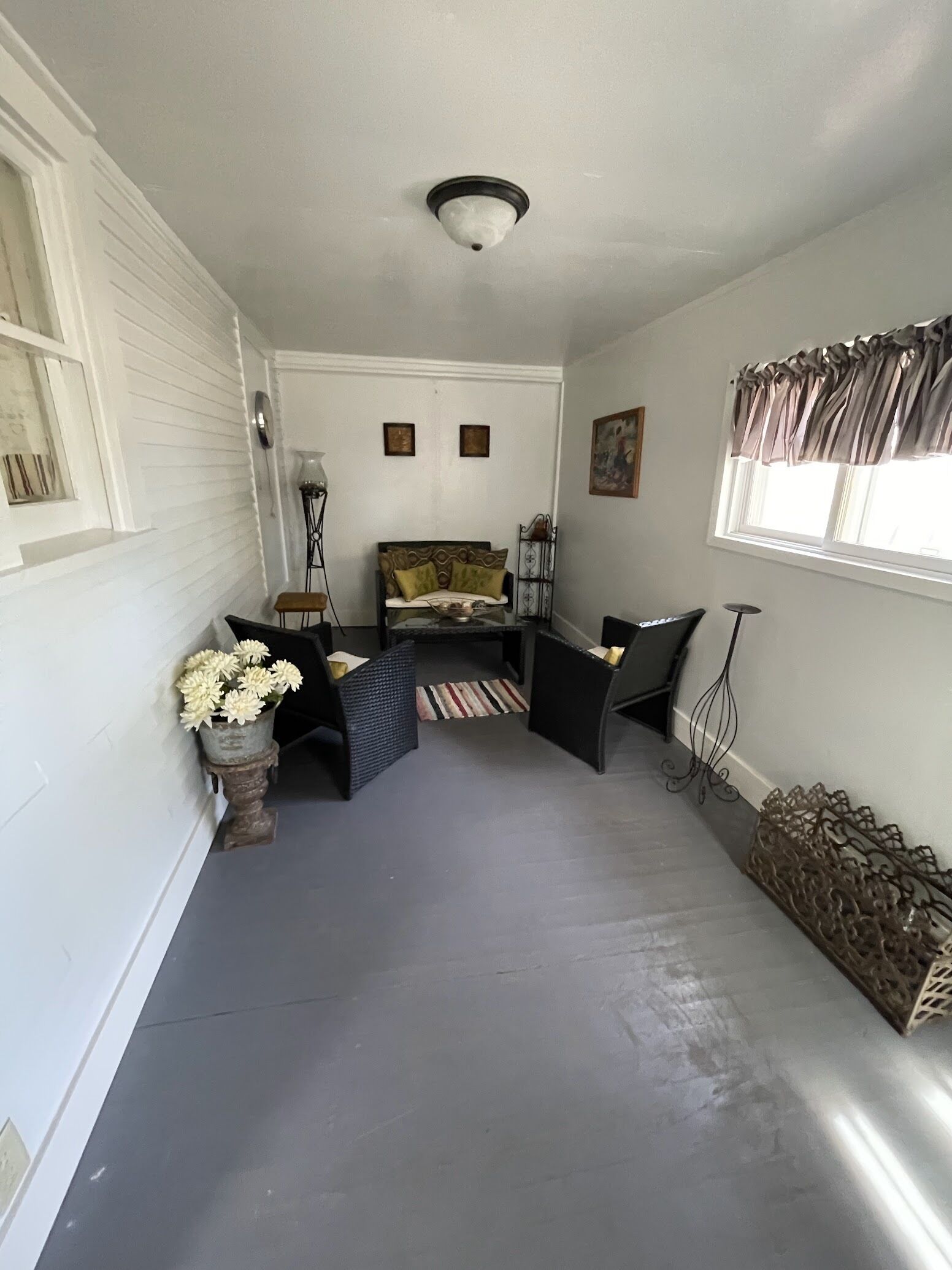 A narrow hallway with a sofa, a small table, and a decorative vase with flowers.
