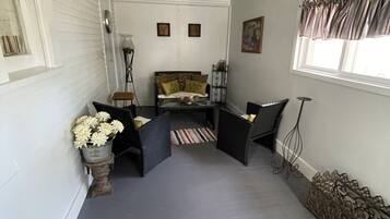 A narrow hallway with a sofa, a small table, and a decorative vase with flowers.