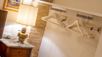 A bathroom with a marble countertop, a brass lamp, a wooden cabinet, and a wall-mounted clothes rack.