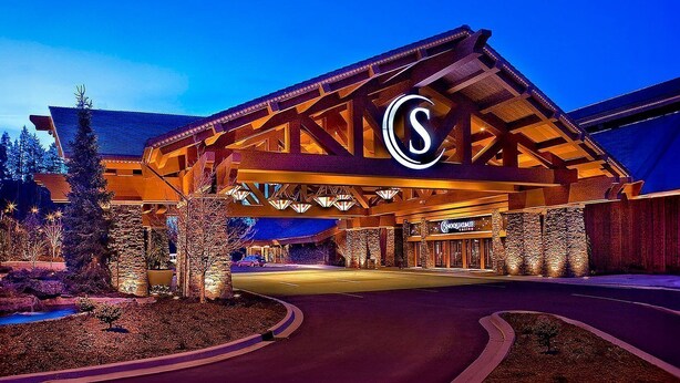 A hotel entrance with a prominent 'S' logo, stone facade, and a well-lit driveway. - 3Bd, 1 bath - Centrally located 15min Airport/Bellevue/Seattle/TopGolf/Hiking (Renton)