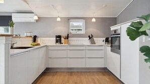 A modern kitchen with white cabinetry, a built-in oven, and a window above the sink. - Amazing home in Børkop with WiFi (Børkop)