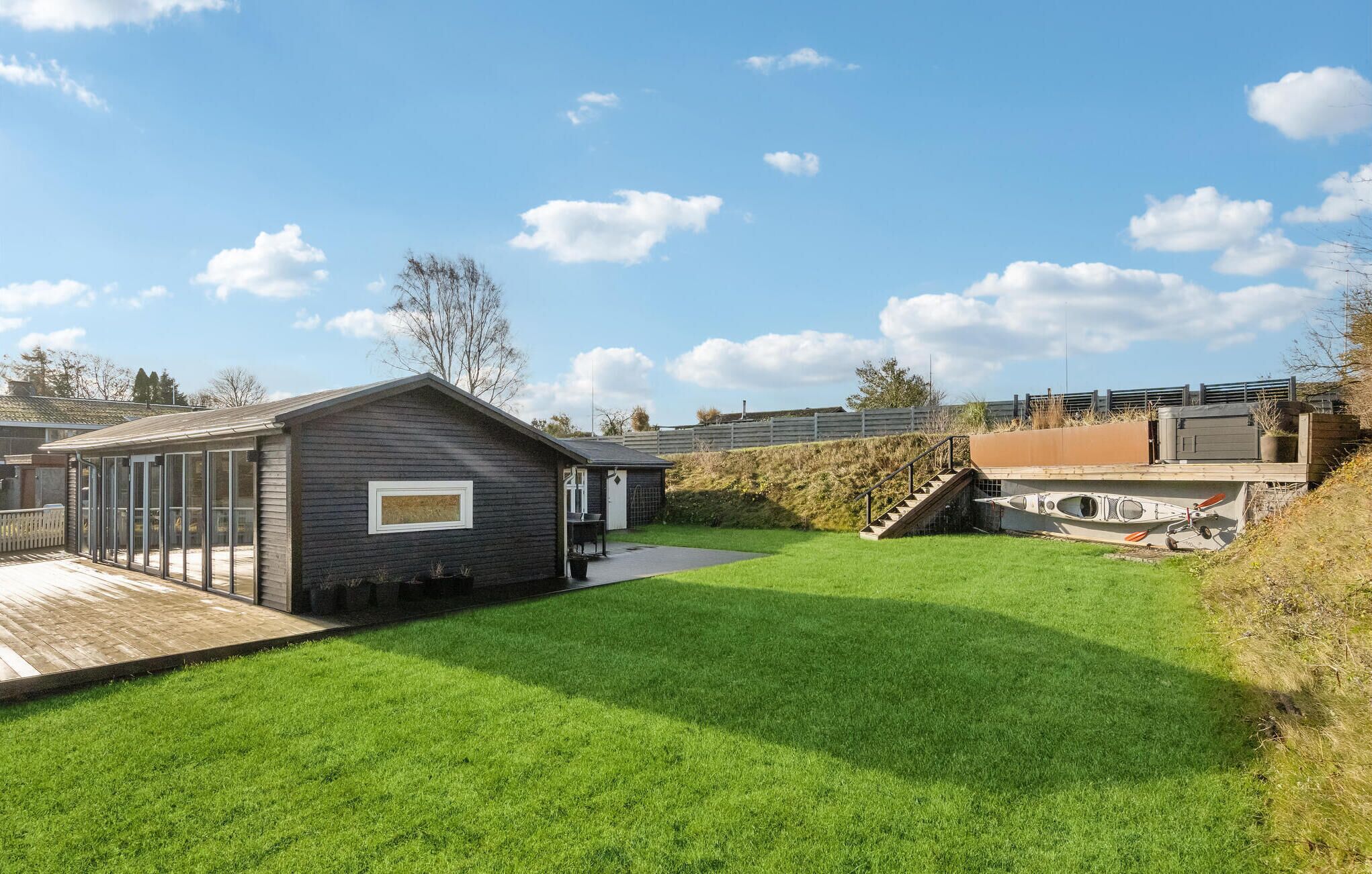 A residential property with a well-maintained lawn, a small shed, and a covered outdoor area.