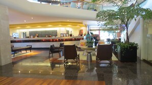 A lobby with a reception desk, seating area, and a staircase. - Amazing view in the beautiful Luana Waikiki! (Honolulu)