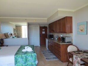 A hotel room with a bed, a desk, a kitchenette, and a bathroom. - Amazing view in the beautiful Luana Waikiki! (Honolulu)