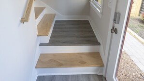 A staircase with wooden steps and a 'WELCOME' mat at the bottom.