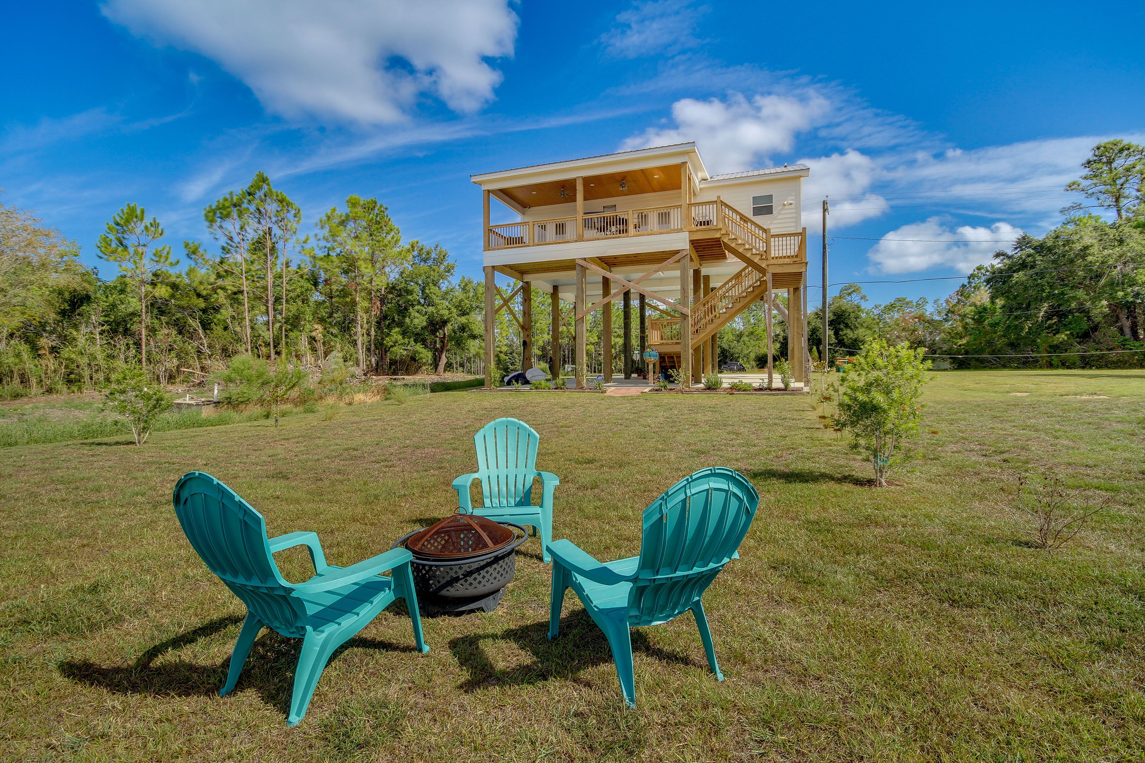 Une maison avec une terrasse et un foyer extérieur dans le jardin.