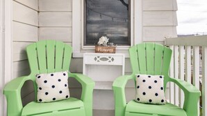 Two green chairs with polka dot cushions on a porch with a window and a small table labeled "Flowers". - Cozy 2nd Floor3 bedroom unit with off street parking (Sinking Spring)