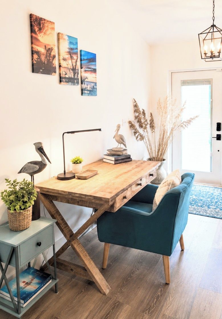 A modern living space with a wooden dining table, a blue sofa, and a wall-mounted lamp.