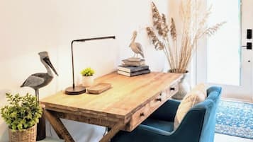 En moderne stue med et træspisebord, en blå sofa og en bogreol.