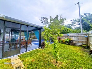 Enjoy a tranquil outdoor space with a seating area, table, and lawn, surrounded by a fence.