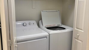 A laundry room with two stacked washers and dryers, a basket on the shelf, and folded towels. - 3-bedroom condo in pleasant Mesquite with AC, WiFi. Enjoy your stay (Mesquite)