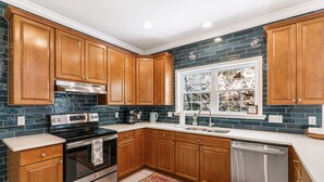 A kitchen with wooden cabinets, a stainless steel stove, and a dishwasher. - 3 minutes to Pisgah Forest Entrance! - Game room - Fire pit   (Pisgah Forest)
