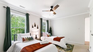 A bedroom with two beds, a ceiling fan, and large windows with curtains. - 3 minutes to Pisgah Forest Entrance! - Game room - Fire pit   (Pisgah Forest)