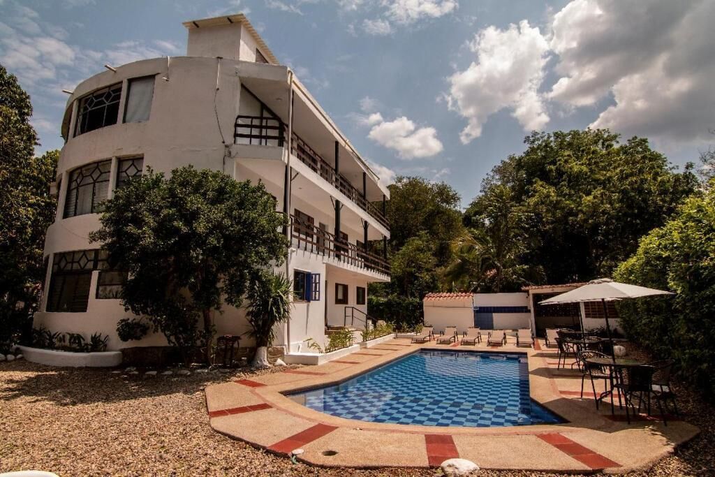 A modern two-story building with a pool and outdoor seating area.