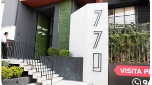 Un edificio moderno con una escalera que conduce a una puerta marcada con el número 77.