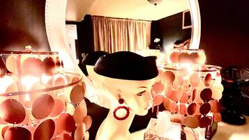 A vanity setup with a large mirror, a makeup table, and a tissue box.