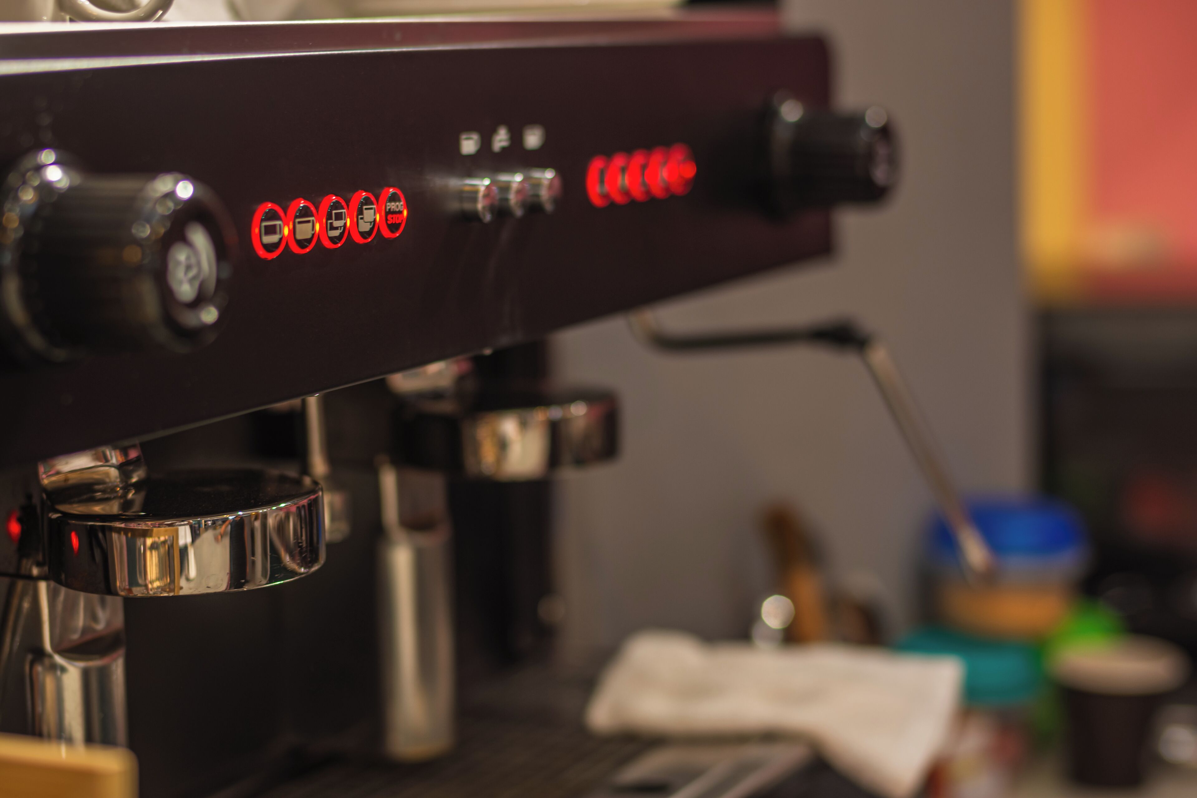 A close-up of a coffee machine with a digital display and control knobs.