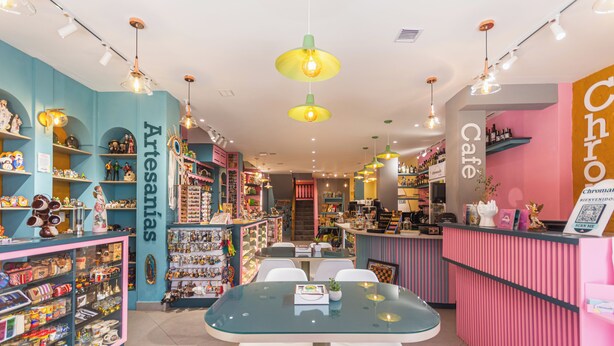 Una boutique luminosa con estantes de productos artesanales y un área de estar central.