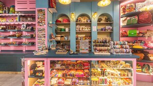 Una tienda bien iluminada con estantes llenos de bolsas, joyas y accesorios coloridos.