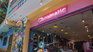 Un edificio colorido con un escaparate llamativo y una moto estacionada afuera.