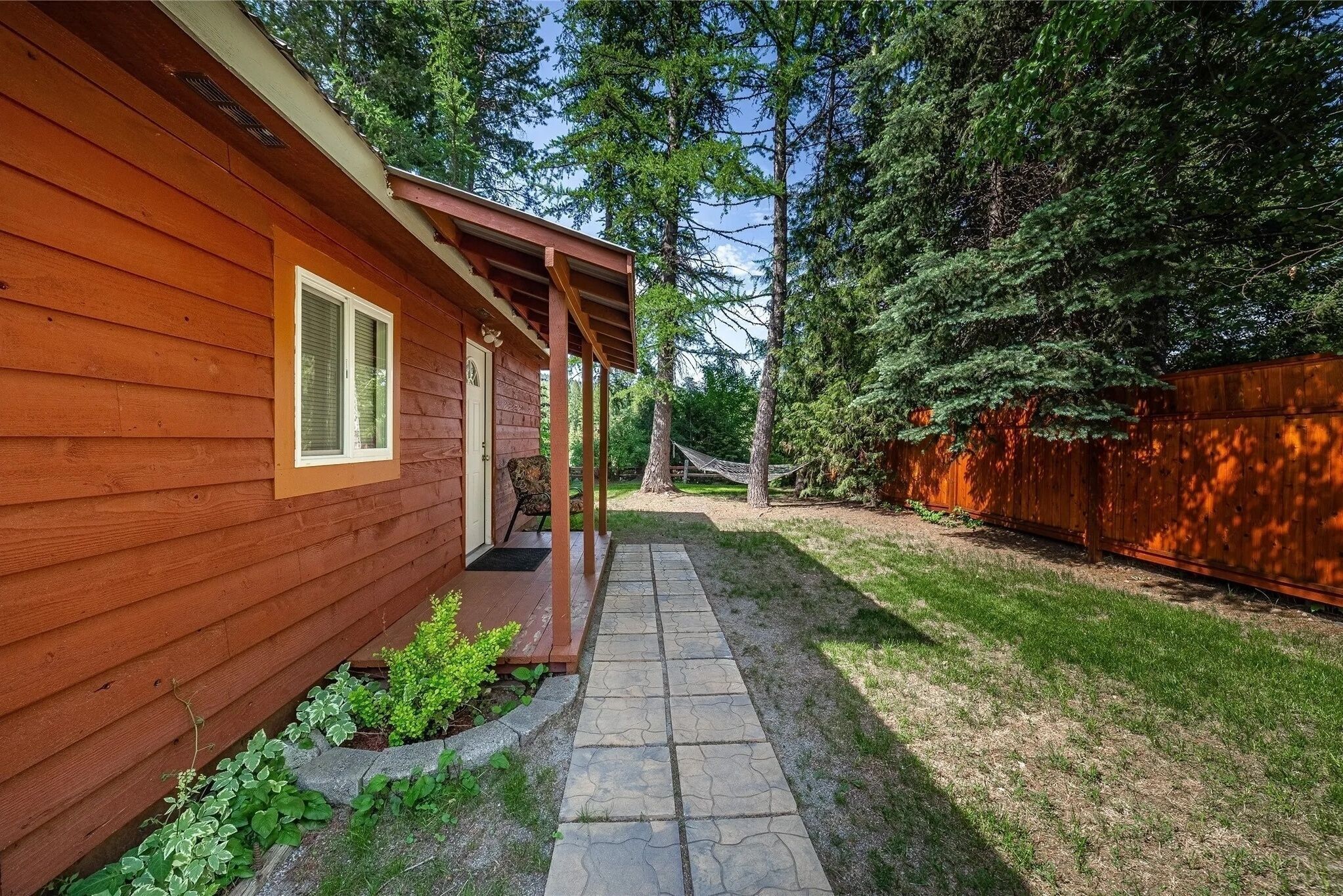 A wooden cabin with a stone pathway leading to a porch.