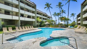 A hotel pool area with multiple lounge chairs and a hot tub. - 2br White Sands Village condo right at the beach (Kailua Kona)