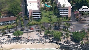 A coastal hotel with multiple buildings, a beach, and a swimming pool. - 2br White Sands Village condo right at the beach (Kailua Kona)